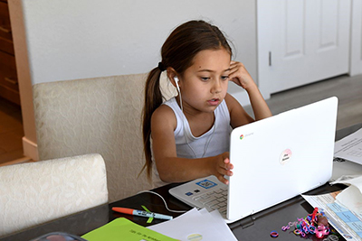 young girl completing school work on pc