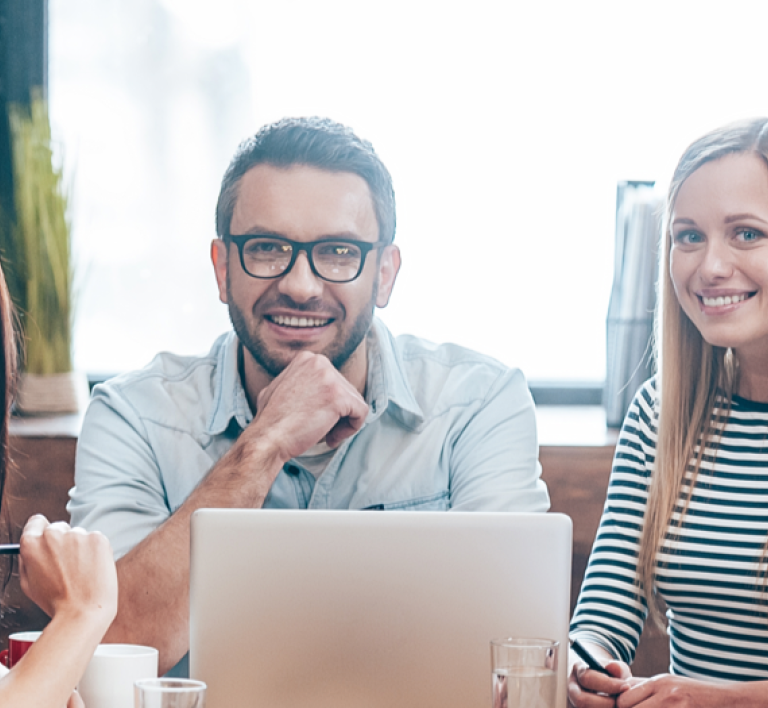 Photo of employees around a conference table smiling